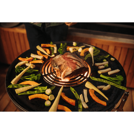 Höfats Bowl vuurschaal. Van bovenaf gefotografeerd met diverse etenswaren op de plancha en sear grate