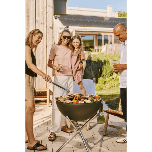 Diverse mensen aan het barbecueën op de Bowl tripod.