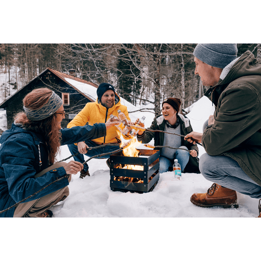 Winters tafereel met de Höfats crate vuurkorf waar mensen eten roosteren boven de vuurkorf.