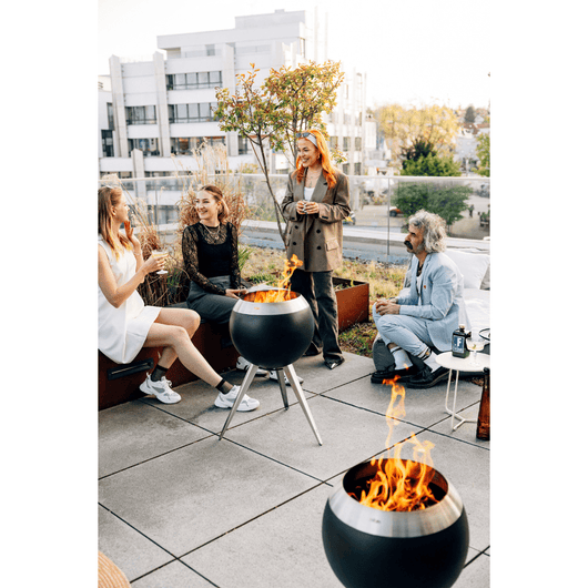 Höfats MOON 45 vuurkorf roestvrijstaal met hoge roestvrijstalen standaard. Brandend vuur op een terras – rookvrije design vuurkorf met houtvergassingstechnologie