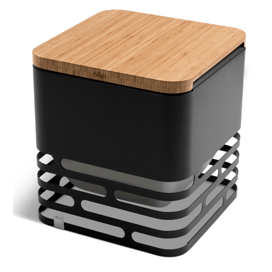 Zwarte Höfats Cube vuurkorf van gepoedercoat roestvrij staal, stijlvolle en multifunctionele vuurkorf met bamboe plank.
