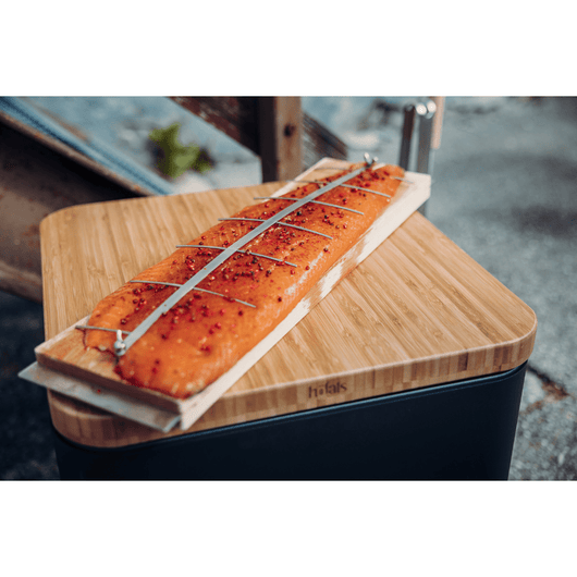 Gerookte zalm op de grillplank. De grillplank ligt op een Höfats Cube vuurkorf met een bamboe plank.