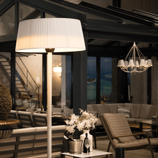Witte staande heater bij een loungestoel onder aluminium veranda.